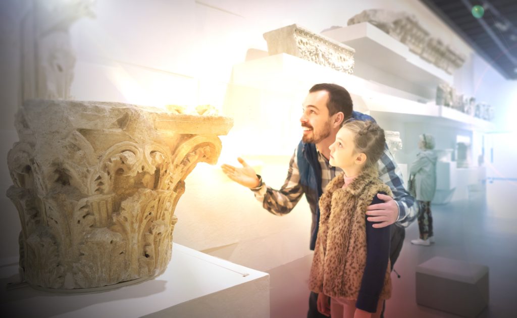 visiteurs contemplant des éléments décoratifs de l'architecture de la période romaine