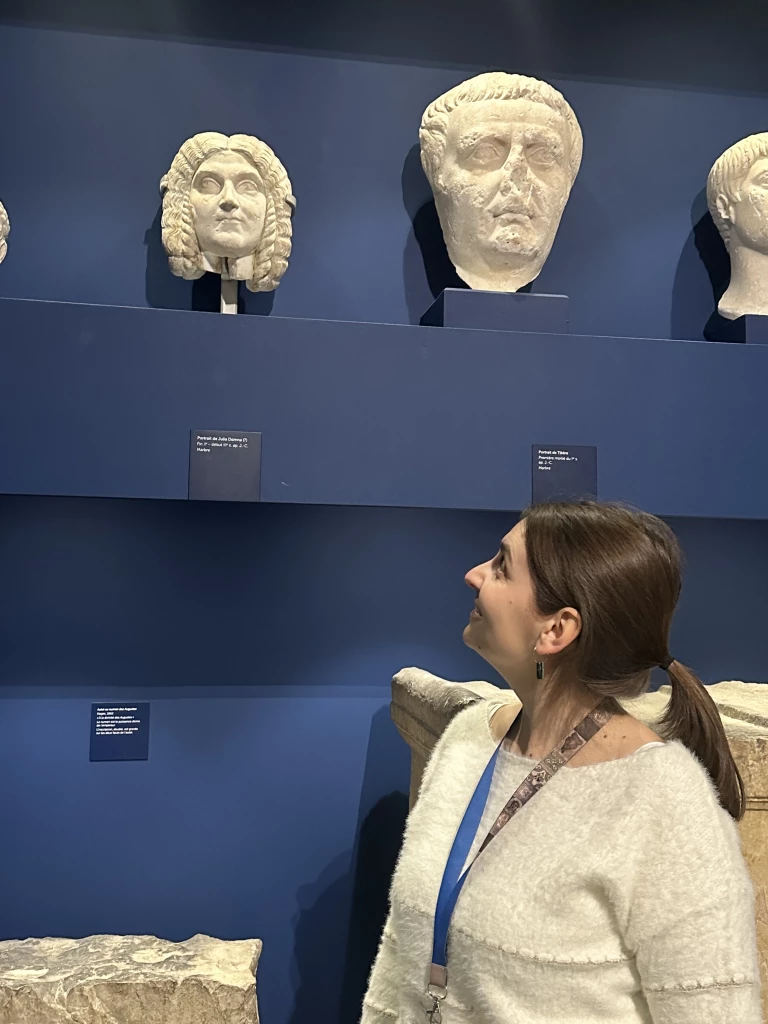 Femme regardant statue pierre sur fond bleu musée